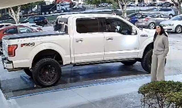 A woman stands in front of a white Ford F-150 pickup truck Wednesday morning, Dec. 31, 2025. Hialeah police believe the woman may have been abducted.
